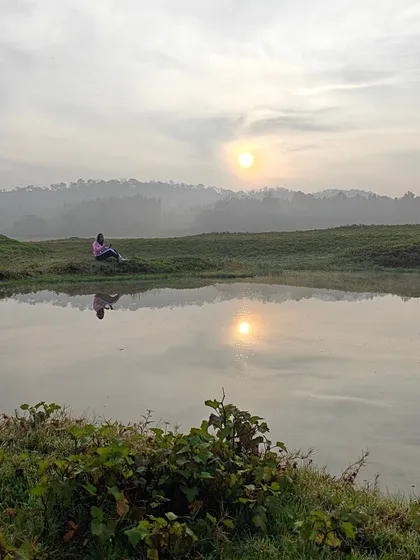 A serene sunrise reflection in a small pond in Coorg. We encourage our travelers to wake up early to witness these quiet, beautiful moments.