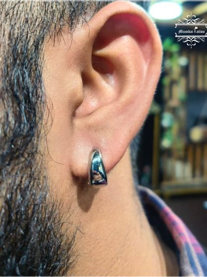 Sometimes a classic lobe piercing with a simple, elegant hoop is all you need. We ensure it's done right for a timeless look.