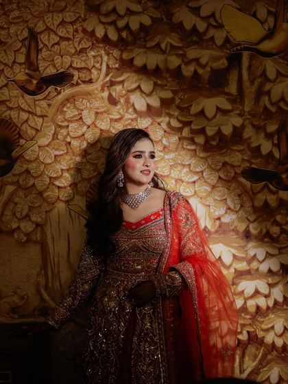A lovely portrait of the bride against a beautifully lit, artistic background. Her soft makeup and elegant outfit create a romantic feel.