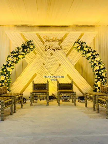 I enjoy creating unique stage designs that reflect the couple's style. This engagement stage features a modern geometric backdrop with crisscrossing drapes, highlighted by two beautiful arches of yellow flowers.