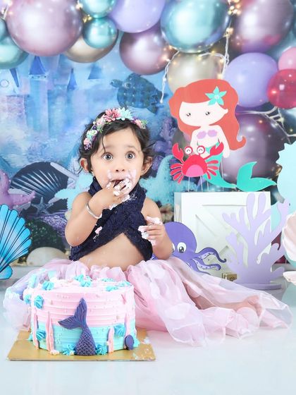 This little mermaid seems surprised by her first taste of cake! An adorable and funny moment from her under-the-sea themed party.