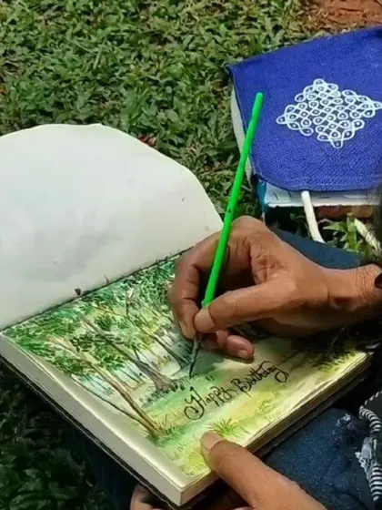 A close-up of my hand sketching the details of the trees in the park.