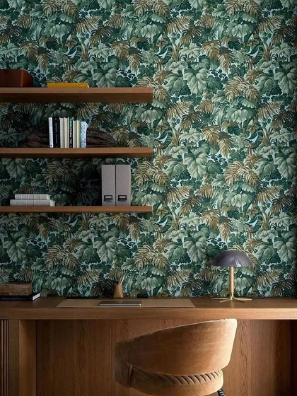 We like our greens sojourned on a wall. This study space features a lush, leafy wallpaper that creates a refreshing and inspiring atmosphere, proving that a touch of nature can elevate any room.