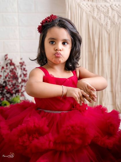 Sassy and sweet in every frame. This little girl in her red dress is full of personality, making for a fun and expressive photoshoot.
