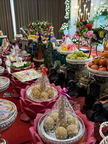 A close-up of the lotus-shaped offering bowls filled with traditional sweets.