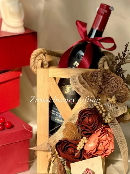 This Christmas, give the gift of elegance. A wooden crate holding a bottle of wine and decorated with rustic, earthy-toned flowers makes for a sophisticated holiday present.