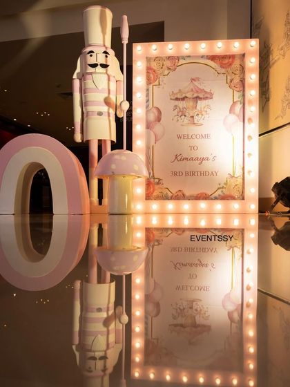 The entrance decor for the carousel-themed party, including a nutcracker figure and a lit-up welcome sign. The reflective flooring adds an extra touch of magic to the setup.