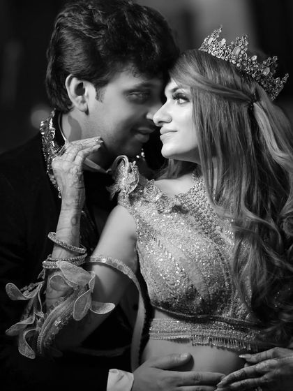 A classic, romantic black and white portrait of the couple, their profiles close together, crowned and ready for their fairytale reception.