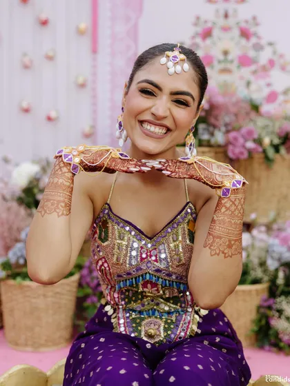 A happy bride showing off her sleek, long braid during her Mehendi ceremony. This style is perfect for keeping long hair managed and beautiful.