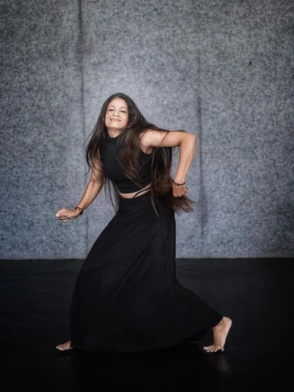 A powerful, grounded stance showing the strength and control that comes from years of dance training.