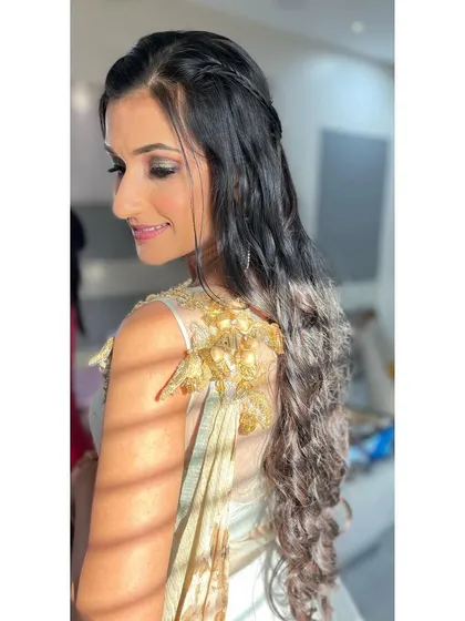 A side profile showcasing the beautiful, long waves and half-up braided hairstyle. This style is perfect for keeping hair off the face while still looking glamorous and romantic.