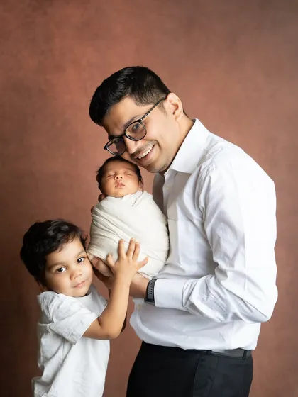 A proud big brother helps his dad hold the new baby. I love including older siblings in newborn sessions to capture the start of their special relationship.