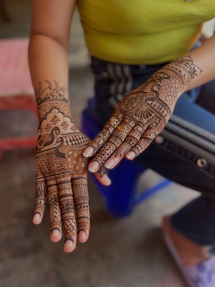 This design features a prominent peacock on one hand and dense, traditional patterns on the other, showcasing a blend of figurative and abstract art.