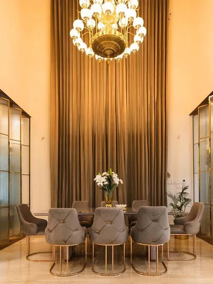 This double-height dining area in a Bangalore villa showcases our ability to create dramatic and elegant spaces. We used custom fluted glass partitions and a grand crystal chandelier to define the space while maintaining an open, airy feel perfect for hosting.