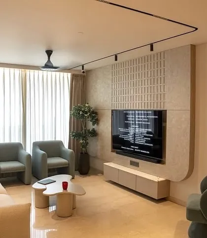The living room in the Oberoi Sky City apartment, featuring a clean, contemporary aesthetic. I used soft, curved furniture and a textured feature wall to create a space that feels modern yet comfortable.