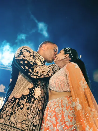 A passionate kiss during the Sangeet night at The Leela Palace in Udaipur. The dramatic lighting and the energy of the moment make this a powerful and memorable shot.