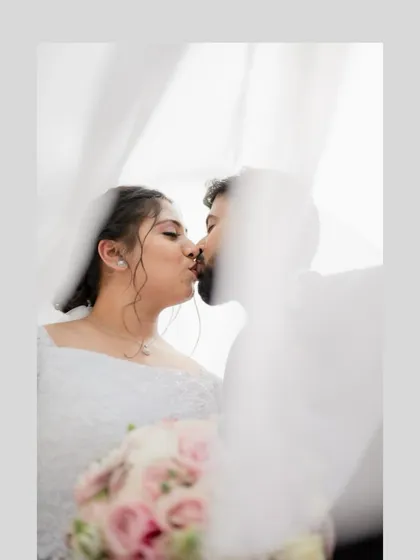 An intimate kiss between the bride and groom, softly veiled. This creates a dreamy and romantic feel for a wedding portrait.