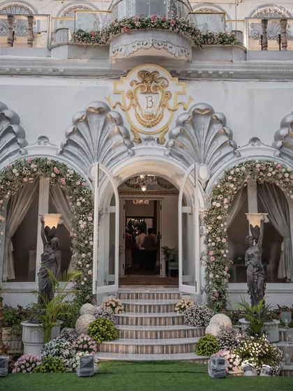 The grand entrance of Birla House adorned with arches of pink and white flowers, setting a tone of understated elegance for the wedding celebration.