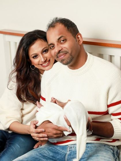 A cozy Christmas family portrait. This photo captures the warmth of a family celebrating their baby's first holiday season together.