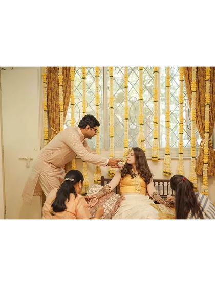 The groom lovingly feeding his bride while she gets her mehendi done. It's these small acts of care that we love to capture.