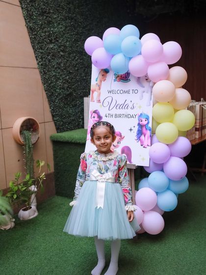 The birthday girl poses by her welcome sign, ready for her magical celebration to begin.