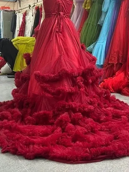 The back view of our wine red ruffled gown showcases the corset lacing and the full, cascading train of ruffles. It's a stunning dress from every angle.