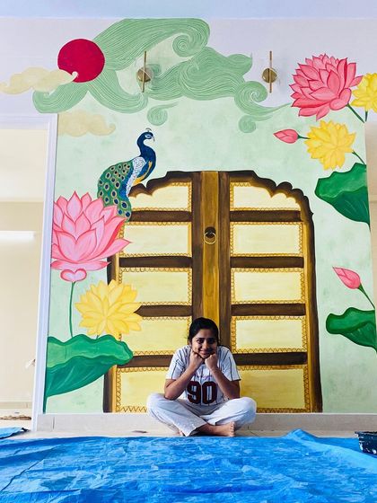 This vibrant, traditional backdrop for a pooja mantap was a wonderful collaboration with our client. It features a painted Jaipur door, Pichwai lotuses, a peacock, and whimsical clouds, all planned in detail.