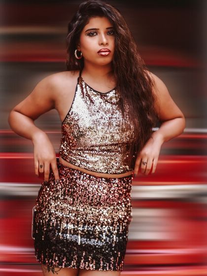 A bold and powerful pose against a motion-blurred red background. This shot is full of energy, attitude, and high-fashion flair.