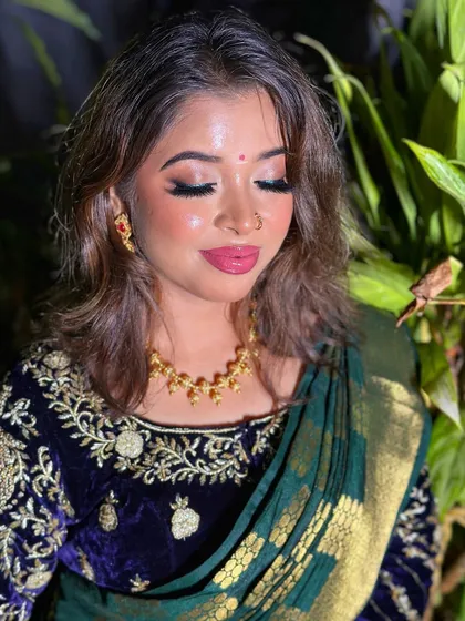 A close-up of the makeup for the modern South Indian look. The focus is on the glowing skin, soft pink lips, and shimmery eyeshadow.