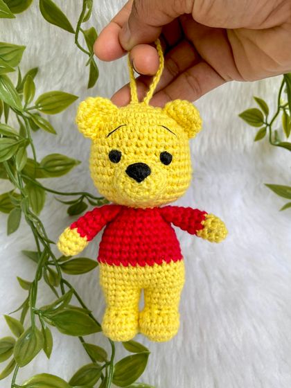 A sweet Winnie the Pooh keychain. This classic character is perfect as a small, adorable accessory to hang on a bag or keys, bringing a little bit of the Hundred Acre Wood with you.