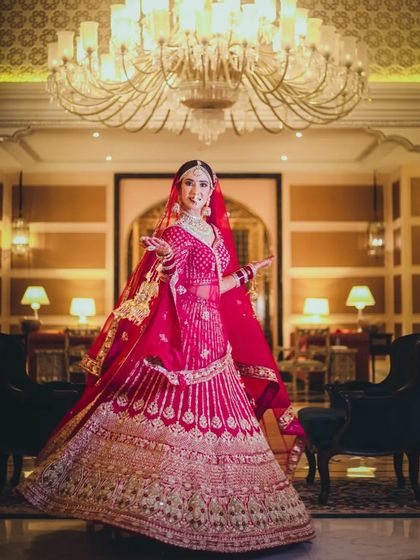 A grand bridal portrait in a luxurious hotel lobby, with the bride in a stunning pink lehenga.