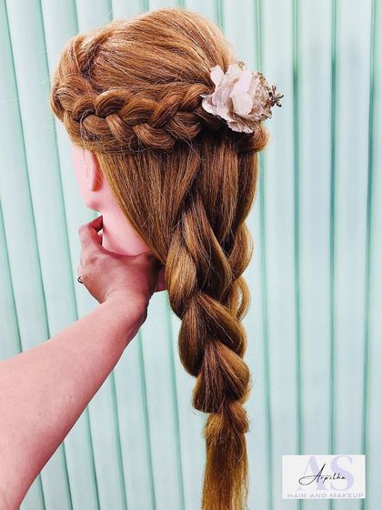 A classic French braid combined with a twisted half-up style, practiced on a mannequin. This demonstrates how we build upon foundational braiding skills to create more complex designs.