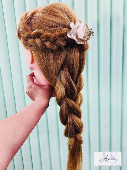 A classic French braid combined with a twisted half-up style, practiced on a mannequin. This demonstrates how we build upon foundational braiding skills to create more complex designs.