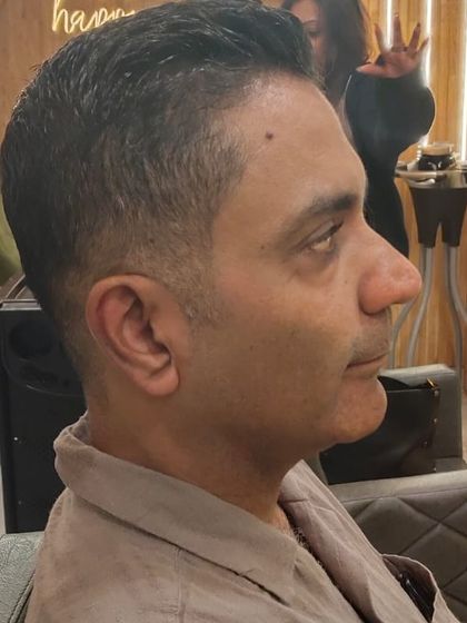 A sharp and clean haircut for men. This side profile shows the precision of the fade and the neat styling on top.