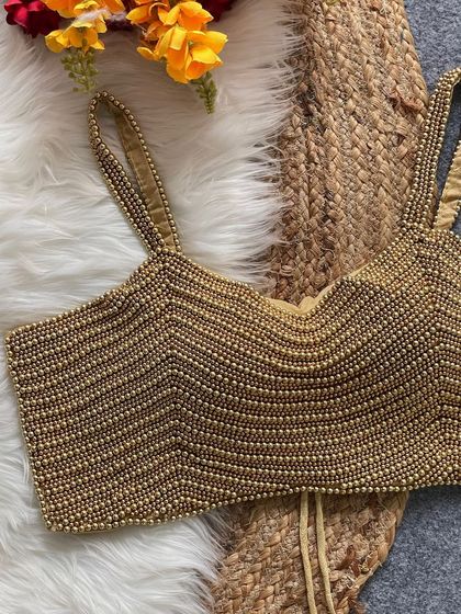 A detailed shot of the golden pearl blouse, highlighting its rich color and texture.
