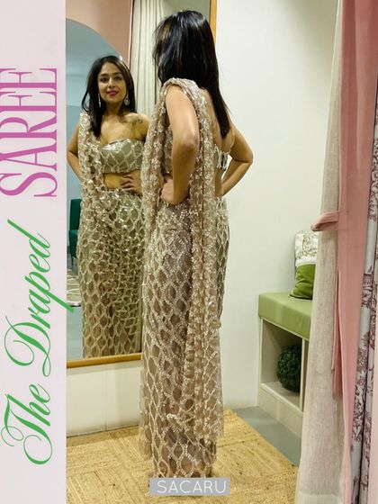 Megha trying on the draped saree dress in our studio, showing the flattering silhouette from the back.