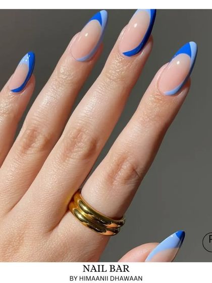A graphic blue French tip design using two shades of blue for a modern, color-blocked effect.