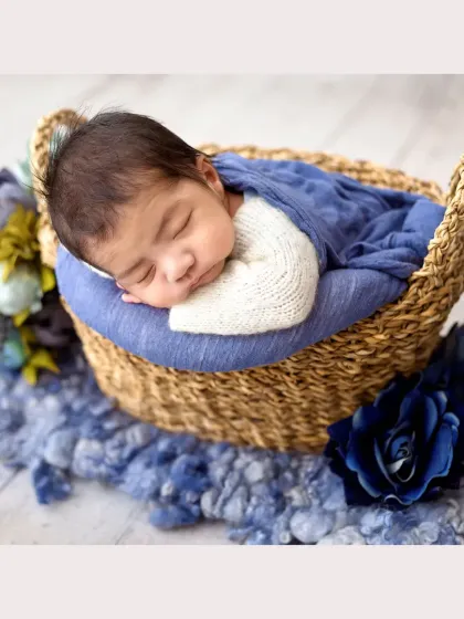I just can't get over the sweetness of this little one. Safely posed and sleeping so peacefully in a rustic woven basket, this classic newborn portrait captures those precious, fleeting moments with a beautiful blue color palette.