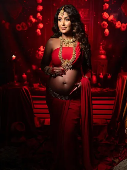 A confident and graceful pose. This shot captures the mother-to-be in her traditional attire, her hand on her hip, exuding strength and beauty in a culturally rich setting.