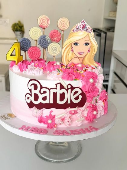A fun and fabulous Barbie cake with pink frosting swirls, lollipops, and a sparkling tiara.