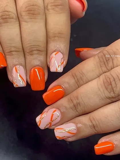A full view of the fun and bright orange abstract nail art.