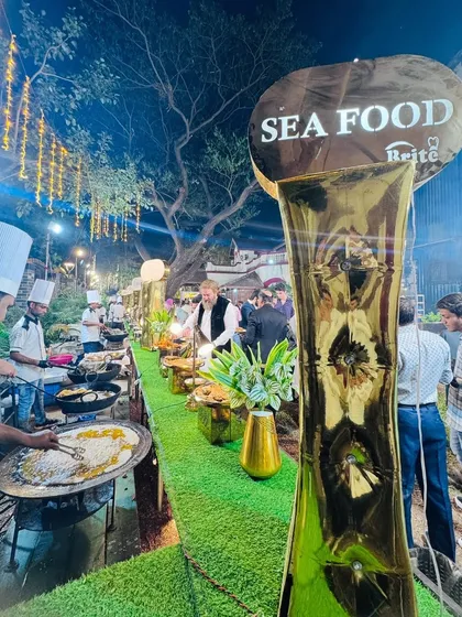 The seafood station is a highlight, with its prominent sign and chefs actively cooking for a line of eager guests.