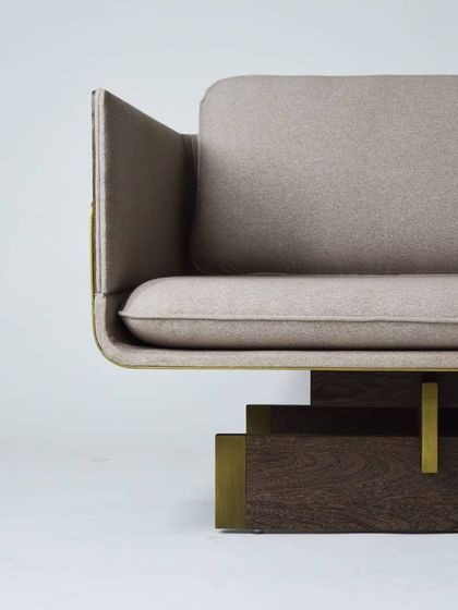 Detail of our TOKYO sofa, inspired by the linear and serene principles of Japanese architecture. The design features a sleek upholstered body resting on a base of Sucupira wood with antique bronze accents.