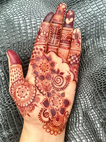 Another angle of the rich henna stain. The deep maroon color contrasts beautifully with the skin, making the floral patterns stand out.