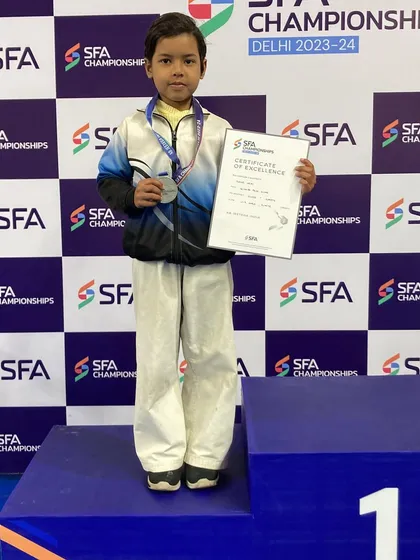 A solo shot of Kavya with her silver medal and certificate. She is a disciplined and promising young karateka.