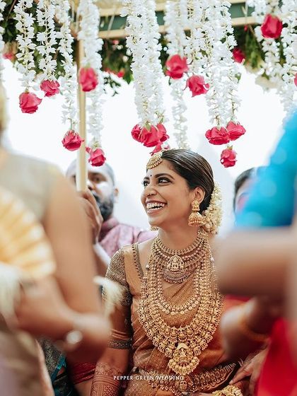 The bride's joyful smile as she is carried in on a palanquin, a beautiful and traditional entrance.
