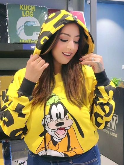 A customer trying on a bright yellow Goofy hoodie. I have a wide range of official Disney merchandise for you to choose from.
