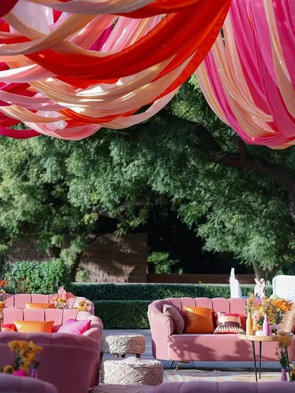 A wide view of the lounge area, with its plush pink seating and colorful drapes creating a festive and luxurious atmosphere.