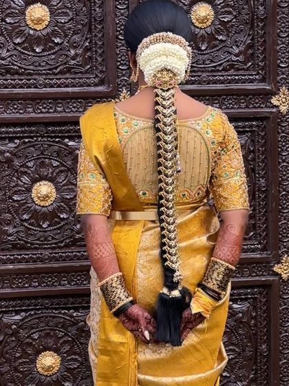 A beautiful bridal braid for a traditional wedding ceremony. The hairstyle features a neat plait decorated with delicate pearl and gold Jada Billa, complemented by a jasmine gajra at the top.