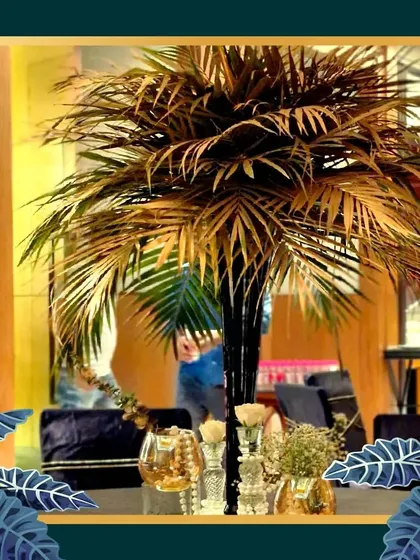 To enhance the tropical Art Deco vibe, we incorporated gilded palm tree props. This centerpiece adds height and a touch of exotic glamour to the event space.